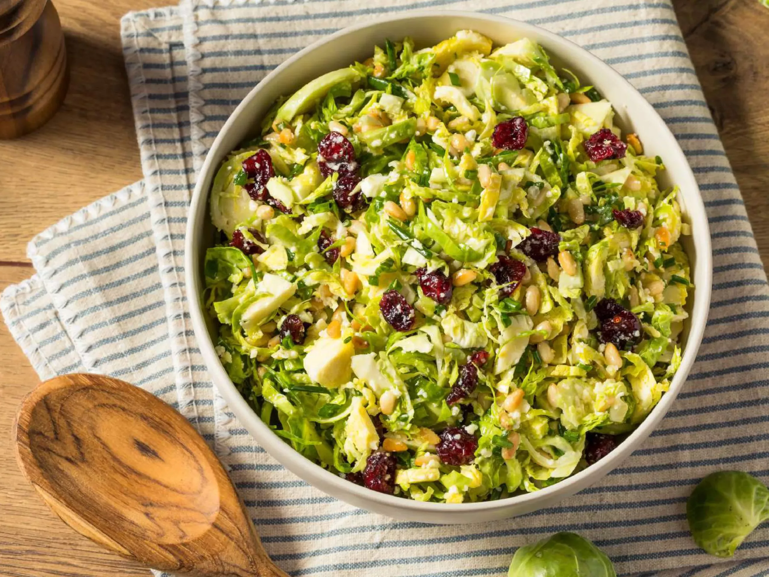 A shaved brussels sprouts salad with cranberries shown from above.