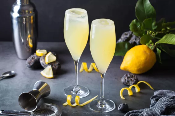 Two glasses of French 75 sit on a countertop, ready to enjoy.