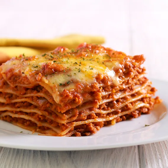 a slice of lasagna on a plate displaying its layers