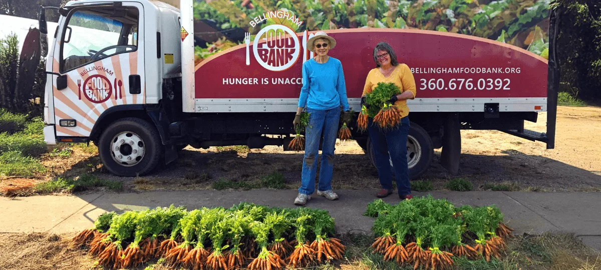 Bellingham Food Bank staff holding organic produce from small local farms