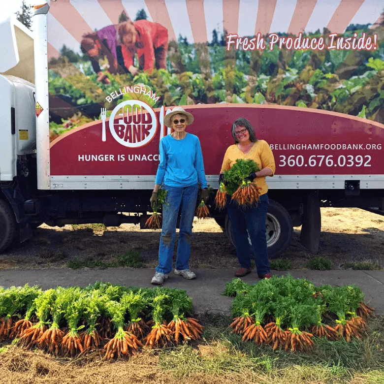 Bellingham Food Bank staff holding organic produce from small local farms